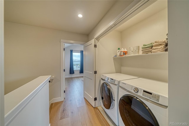 washroom featuring washer and clothes dryer and light hardwood / wood-style flooring