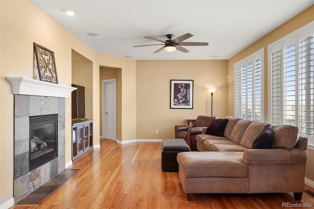 living room featuring a healthy amount of sunlight, light hardwood / wood-style floors, and a tile fireplace