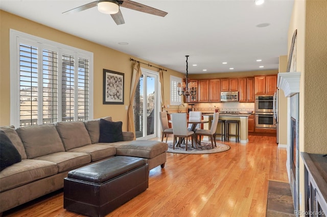 living room featuring ceiling fan and light hardwood / wood-style flooring