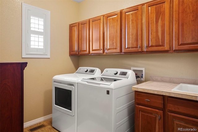 laundry room with cabinets, sink, and washing machine and clothes dryer