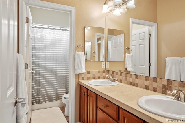 bathroom with vanity, toilet, and backsplash