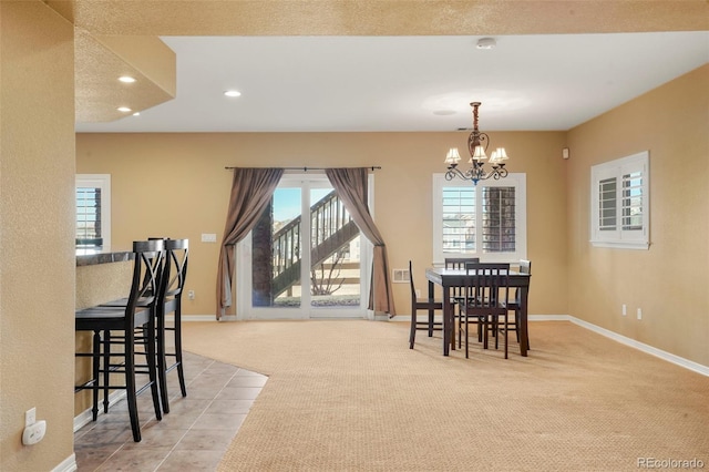 carpeted dining room featuring a chandelier