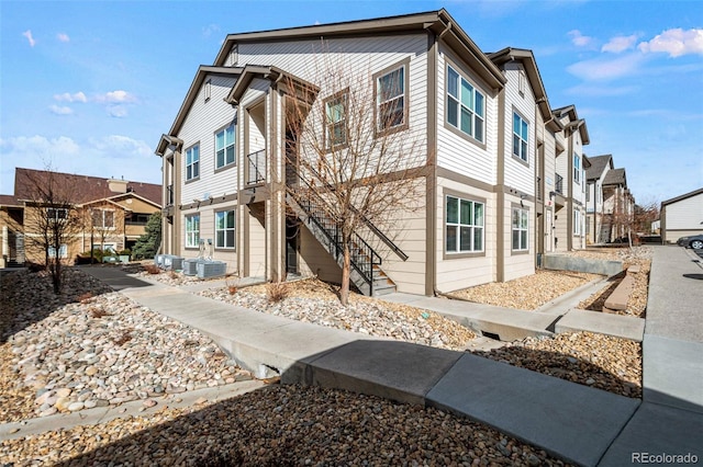 exterior space with central AC, stairway, and a residential view