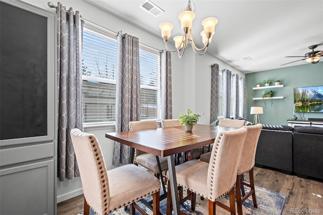 dining area featuring visible vents, dark wood finished floors, baseboards, and ceiling fan with notable chandelier