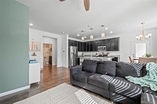 living area with baseboards, dark wood finished floors, and recessed lighting