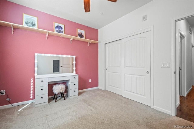 unfurnished bedroom featuring a closet, light colored carpet, ceiling fan, and baseboards