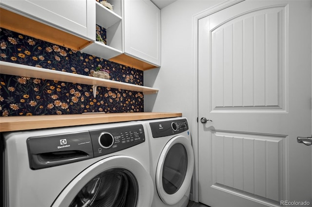 washroom with washer and dryer and cabinet space