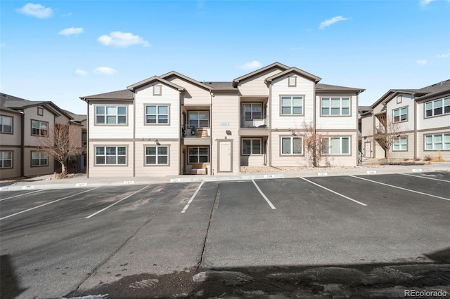 view of building exterior featuring uncovered parking and a residential view