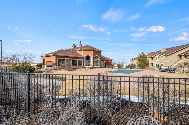 back of house featuring a fenced in pool, fence, a patio, and stucco siding