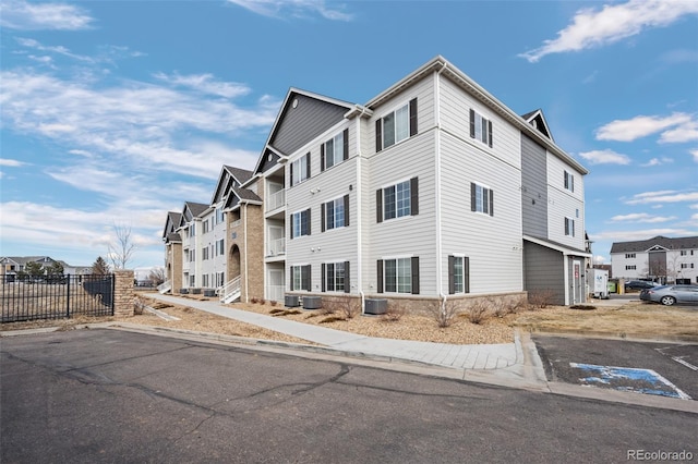 exterior space featuring central air condition unit, a residential view, and fence