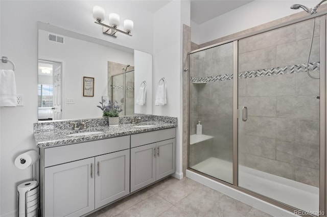 full bathroom featuring a sink, visible vents, a stall shower, and double vanity