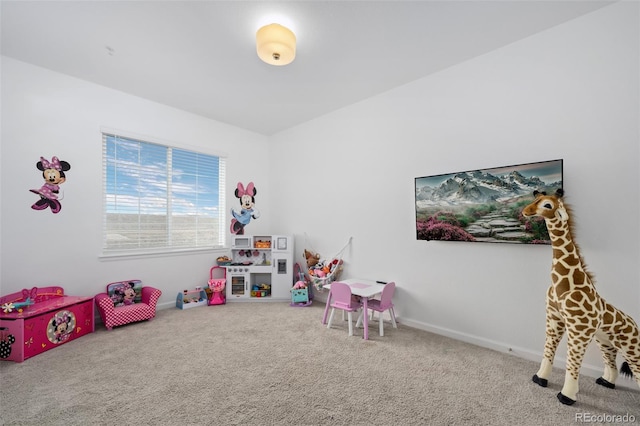 recreation room with baseboards and carpet