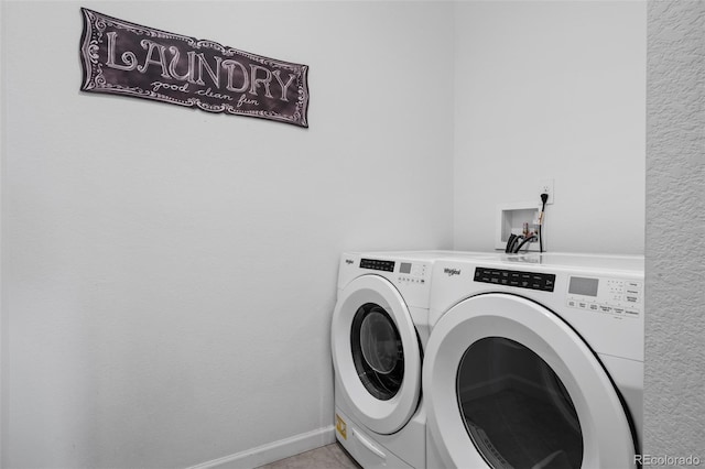 washroom featuring laundry area, baseboards, and washing machine and clothes dryer