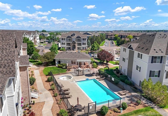 community pool featuring a patio area, a residential view, and fence