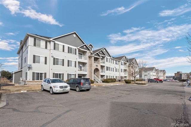 view of property with uncovered parking and a residential view