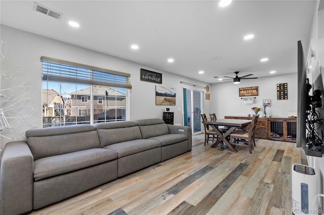 living room featuring ceiling fan and light hardwood / wood-style floors