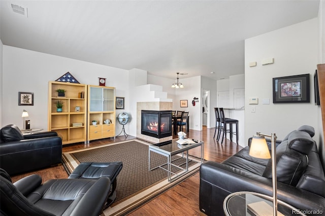12753 Leyden St Unit C, Thornton, CO 80602 - living area featuring wood finished floors, a tile fireplace, and a chandelier
