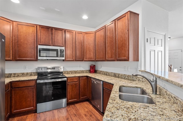 12753 Leyden St Unit C, Thornton, CO 80602 - kitchen featuring appliances with stainless steel finishes, wood finished floors, light stone counters, and recessed lighting