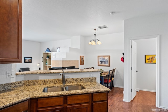 12753 Leyden St Unit C, Thornton, CO 80602 - kitchen featuring wood finished floors, a chandelier, light stone countertops, and pendant lighting