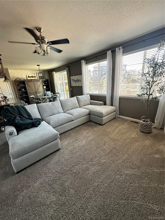 carpeted living area featuring a textured ceiling, plenty of natural light, and ceiling fan
