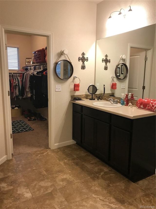 3173 Youngheart Way, Castle Rock, CO 80109 - bathroom with double vanity, a spacious closet, and baseboards