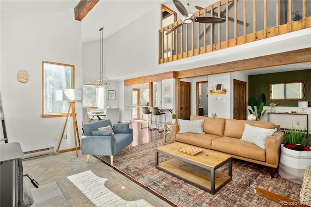 living room featuring ceiling fan, a towering ceiling, and a baseboard radiator