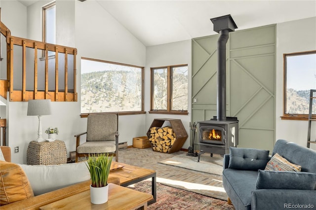 living room featuring high vaulted ceiling and a wood stove