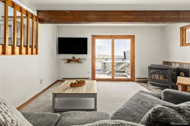 living room with beamed ceiling, a wood stove, and a baseboard heating unit