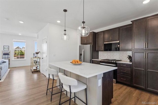 175 Westerly Blvd, Erie, CO 80516 - kitchen with stainless steel fridge with ice dispenser, gas stove, a center island, wood finished floors, and recessed lighting