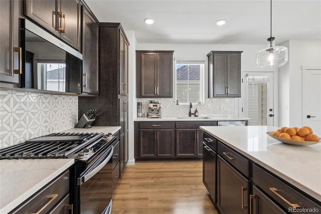 175 Westerly Blvd, Erie, CO 80516 - kitchen with stainless steel appliances, light wood-type flooring, dark brown cabinets, hanging light fixtures, and recessed lighting