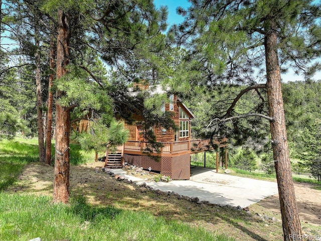 13190 Coyote Song Trl, Conifer, CO 80433 - view of yard with a deck, concrete driveway, a carport, and stairs