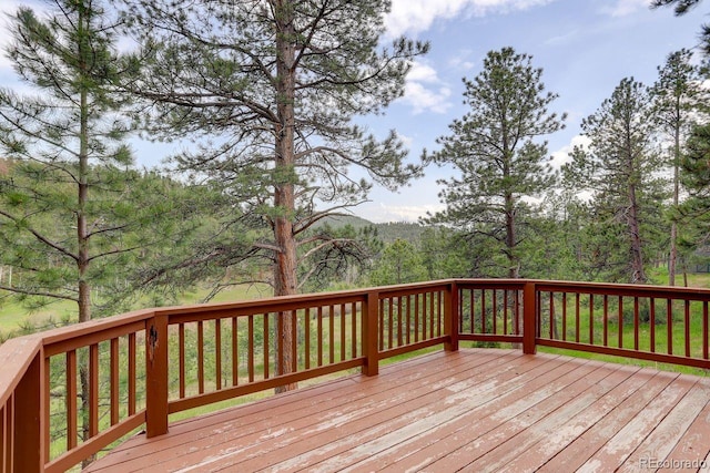 13190 Coyote Song Trl, Conifer, CO 80433 - wooden terrace featuring a wooded view