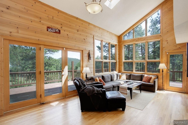 13190 Coyote Song Trl, Conifer, CO 80433 - living room with wooden walls, wood finished floors, high vaulted ceiling, and a skylight