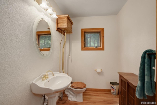 13190 Coyote Song Trl, Conifer, CO 80433 - half bath featuring wood finished floors, toilet, baseboards, and a sink