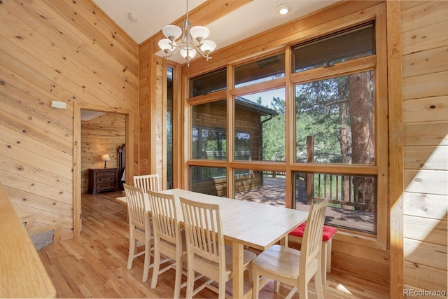 13190 Coyote Song Trl, Conifer, CO 80433 - dining area with wood walls, a chandelier, and light wood-type flooring