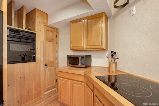 13190 Coyote Song Trl, Conifer, CO 80433 - kitchen featuring black appliances, wooden counters, and light wood-style flooring