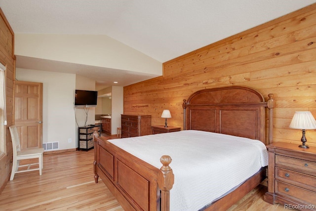 13190 Coyote Song Trl, Conifer, CO 80433 - bedroom with vaulted ceiling, wooden walls, light wood-style floors, and baseboards