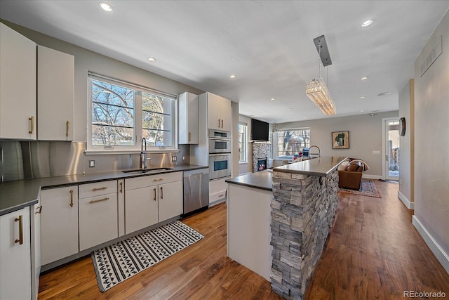 kitchen featuring a kitchen island with sink, appliances with stainless steel finishes, sink, and white cabinets