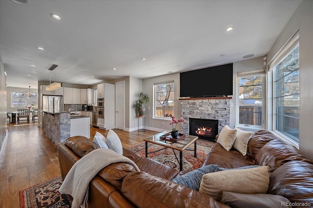 living room featuring a fireplace, a wealth of natural light, and light wood-type flooring