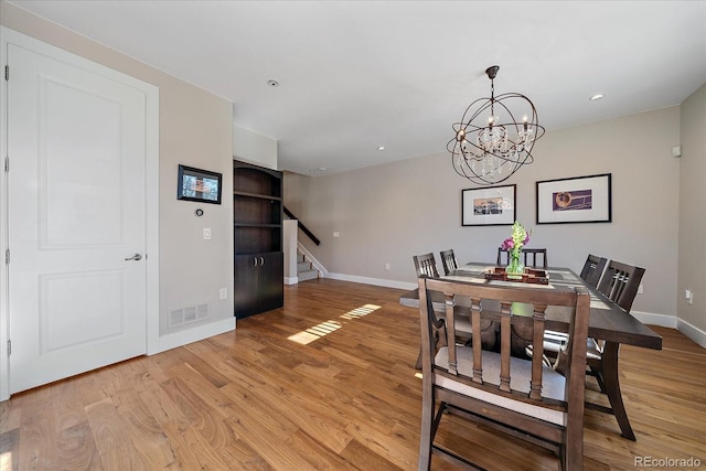 dining area with a notable chandelier and light hardwood / wood-style flooring