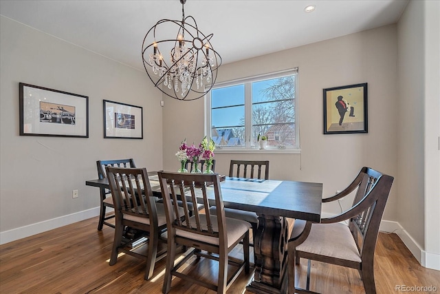 dining area with wood-type flooring and an inviting chandelier