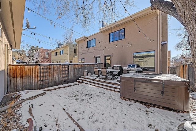 snow covered property featuring a hot tub