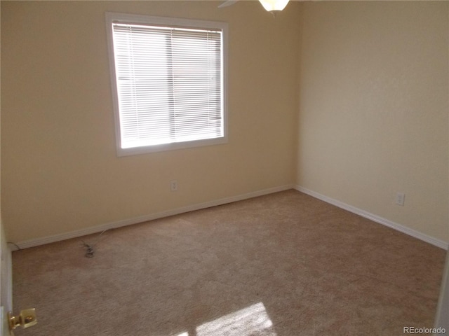 carpeted spare room featuring baseboards