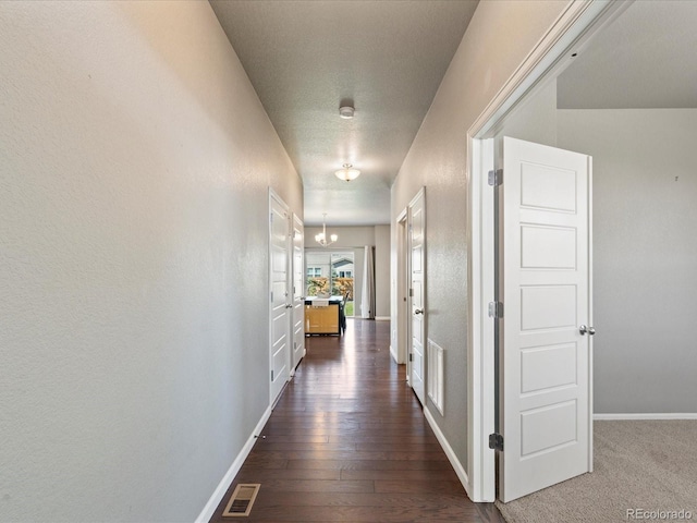 corridor featuring a textured ceiling and dark hardwood / wood-style floors