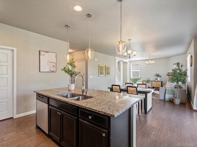 kitchen with sink, dishwasher, a kitchen island with sink, and pendant lighting