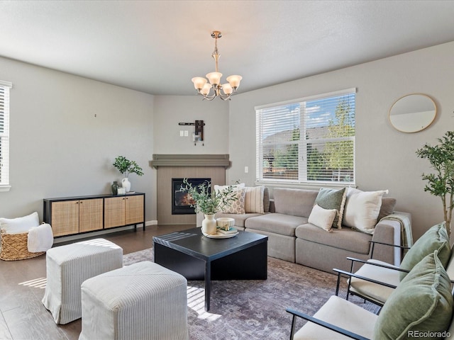 living room with a fireplace, hardwood / wood-style floors, and a notable chandelier