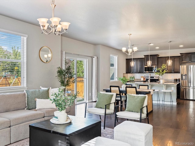 living room featuring an inviting chandelier and dark wood-type flooring