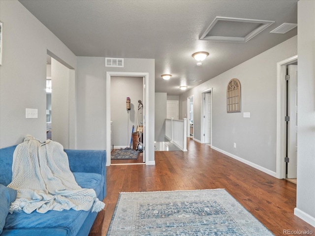 living area with dark wood-type flooring and a textured ceiling