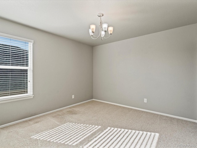 unfurnished room featuring a chandelier and carpet flooring