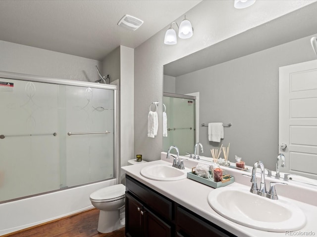 full bathroom with vanity, shower / bath combination with glass door, toilet, and hardwood / wood-style flooring